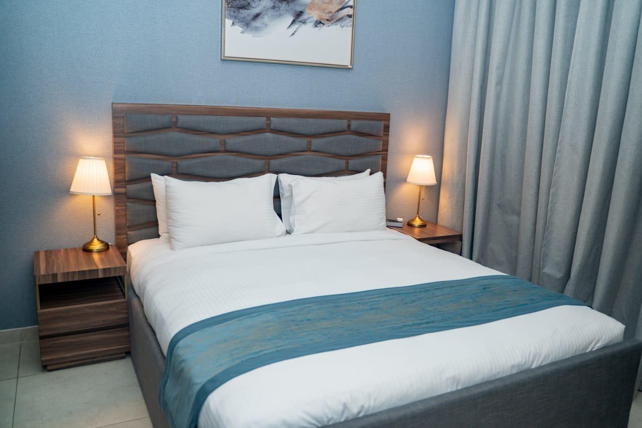 Luxe Grand Hotel Apartments Sharjah Esterno foto A bed with a bed runner